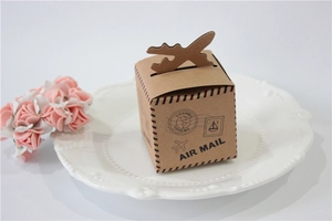 Detail of vintage kraft paper air mail gift box with airplane closure on white tray