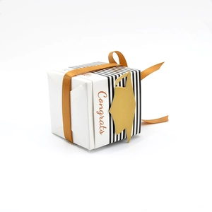 Close-up of white graduation gift box with gold Congrats text and doctoral cap tag