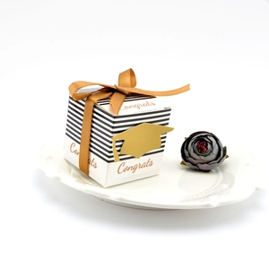 Close-up of a graduation favor box with a gold mortarboard and 'Congrats' text on a plate