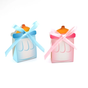 Détail de boîtes cadeaux biberons rose et bleu en carton avec des nœuds en satin