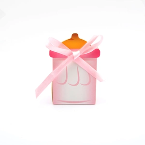 Vue détaillée de la boîte cadeau rose en forme de biberon avec un nœud en soie rose