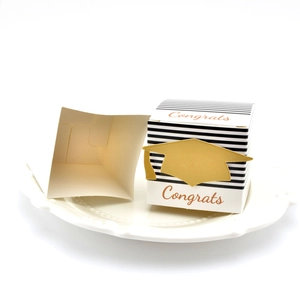 Detail of graduation gift boxes with congrats text and gold foil doctoral hat emblem