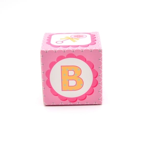 Detail of pink square baby shower favor box with yellow letter B and rattle design