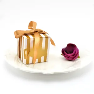 Doctor hat graduation candy box with gold stripes and ribbon on white plate