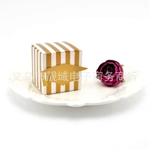 Gold and white striped graduation favor box with a doctoral cap silhouette on a white plate