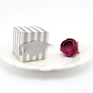 Close-up of doctoral cap themed favor box with grey stripes on a white ceramic tray