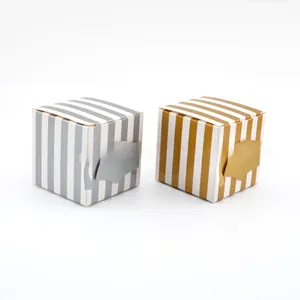 Detail of square kraft paper candy boxes with gold and silver stripes and graduation caps
