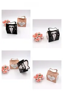 Detail view of tuxedo and gown wedding favor boxes with heart-shaped handles and rhinestone trim