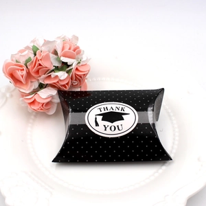 Close-up of black polka dot graduation gift box with Thank You label and mortarboard icon