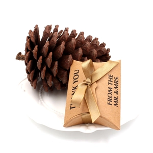 Dettaglio scatola regalo in carta kraft con nastro dorato e testo di ringraziamento per nozze