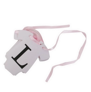 Dettaglio di cartoncino a forma di body con lettera L e nastro rosa per decorazioni