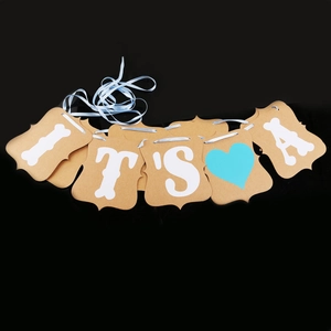 Détail d'une bannière en papier kraft avec texte It's A et cœur bleu pour déco de baby shower
