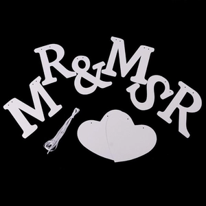 White cardstock MR & MRS wedding banner set with heart shapes and string on black background