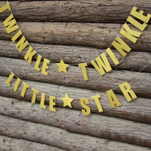 Detail der Twinkle Twinkle Little Star Glitzergirlande an einer Holzwand aufgehängt