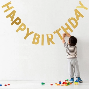 Detail der gold glitzernden Happy Birthday Girlande an weißer Wand für Partydekorationen