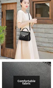 Detail of black pebbled leather tote with pearl buckle and metal woven edges on flap
