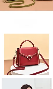 Detail of red leather handbag featuring pearl ring buckle and golden V-stitch accents