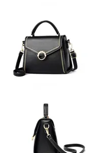 Close-up of black leather bag with gold ring buckle and elegant faux pearl detail