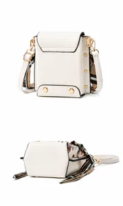 White faux leather crossbody bag detail with gold hexagonal studs and geometric scarf strap
