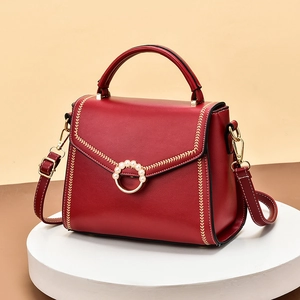 Elegant red leather tote bag with pearl-inlaid gold clasp and embroidery details