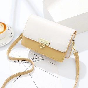 Two-tone yellow and beige small square crossbody bag with clover metal clasp and shoulder strap