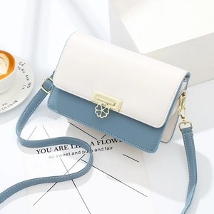 Chic two-tone crossbody bag in cream and light blue with a gold clover pendant