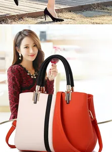 Detail of color-block handbag with lychee texture and black round handle for women