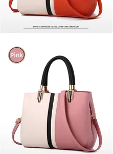 Detail of pink color-block handbag showing lychee leather texture and gold hardware