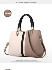 Detailed shot of khaki color block handbag featuring pebble leather texture and gold hardware