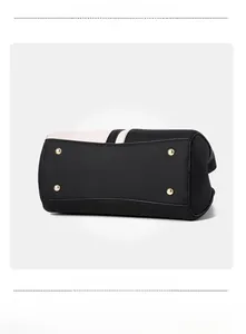 Macro view of textured black lychee leather bag with golden bottom protective studs