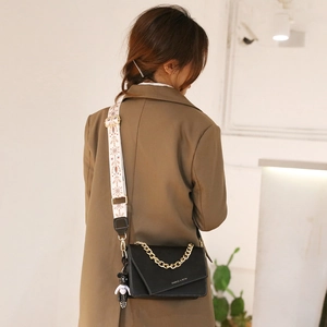 Women's black crossbody bag with gold chain strap and snowflake print shoulder strap