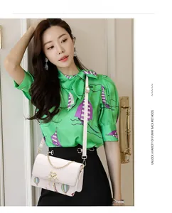 Petit sac bandoulière rose en similicuir avec chaîne et imprimés sur chemise verte