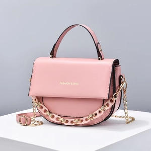 Détail d'un sac à main en cuir PU rose avec chaîne en résine et logo doré élégant