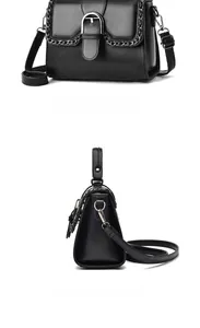 Detail view of the black leather shoulder bag showing the silver U-shaped metal buckle
