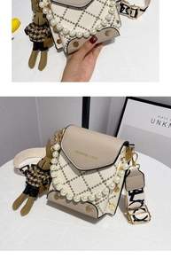 Détail du sac beige matelassé avec chaîne en perles, bandoulière large et lapin