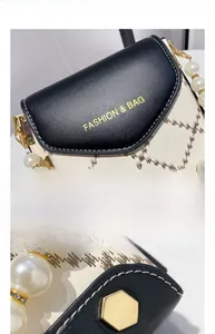 Détail du mini sac bandoulière avec poignée en perles et fermoir hexagonal doré