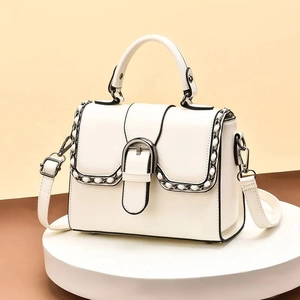 Elegant cream leather crossbody handbag with gold chain trim and U-shaped buckle detail