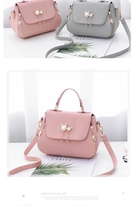Detail of pink and grey crossbody bags with litchi texture and pearl cat charm