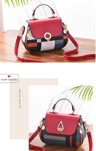 Detail of red and geometric print handbag with gold hardware and top handle on wood