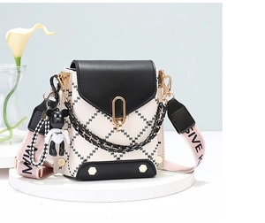 Detail of mini crossbody phone bag with black flap and golden oval twist-lock