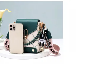 Detail view of mini crossbody phone bag next to smartphone showing size comparison