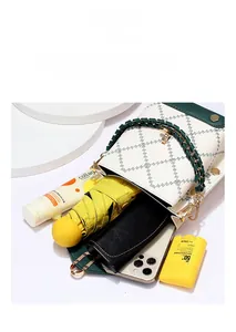 High-capacity crossbody bag showing internal storage for phone, umbrella, and cosmetics