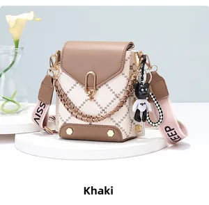 Detail of khaki leather crossbody bag with U-shaped gold lock and bear charm