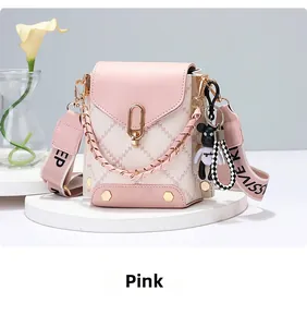 Detailed shot of pink quilted mini crossbody bag with gold chain and plush toy charm