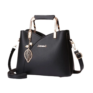 Minimalist black matte crossbody bag with gold metal handle and pearl leaf pendant