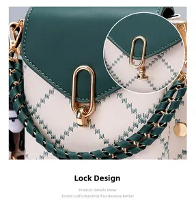 Detail of the golden oval metal clasp and green quilted embroidery on the mini bag