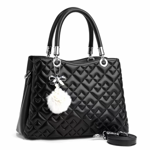 Black quilted faux leather tote bag with silver bow charm and detachable strap
