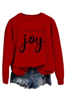 Detail of red crewneck sweatshirt with choose joy text and heart graphic on cotton fabric