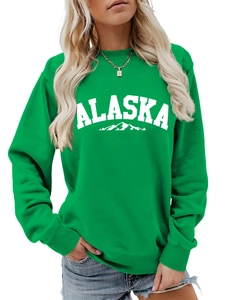 Close-up of bright green Alaska sweatshirt featuring mountain print and ribbed neckline
