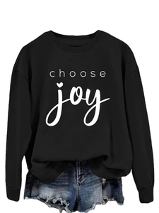 Detail of Choose Joy print on black crewneck sweatshirt paired with denim shorts